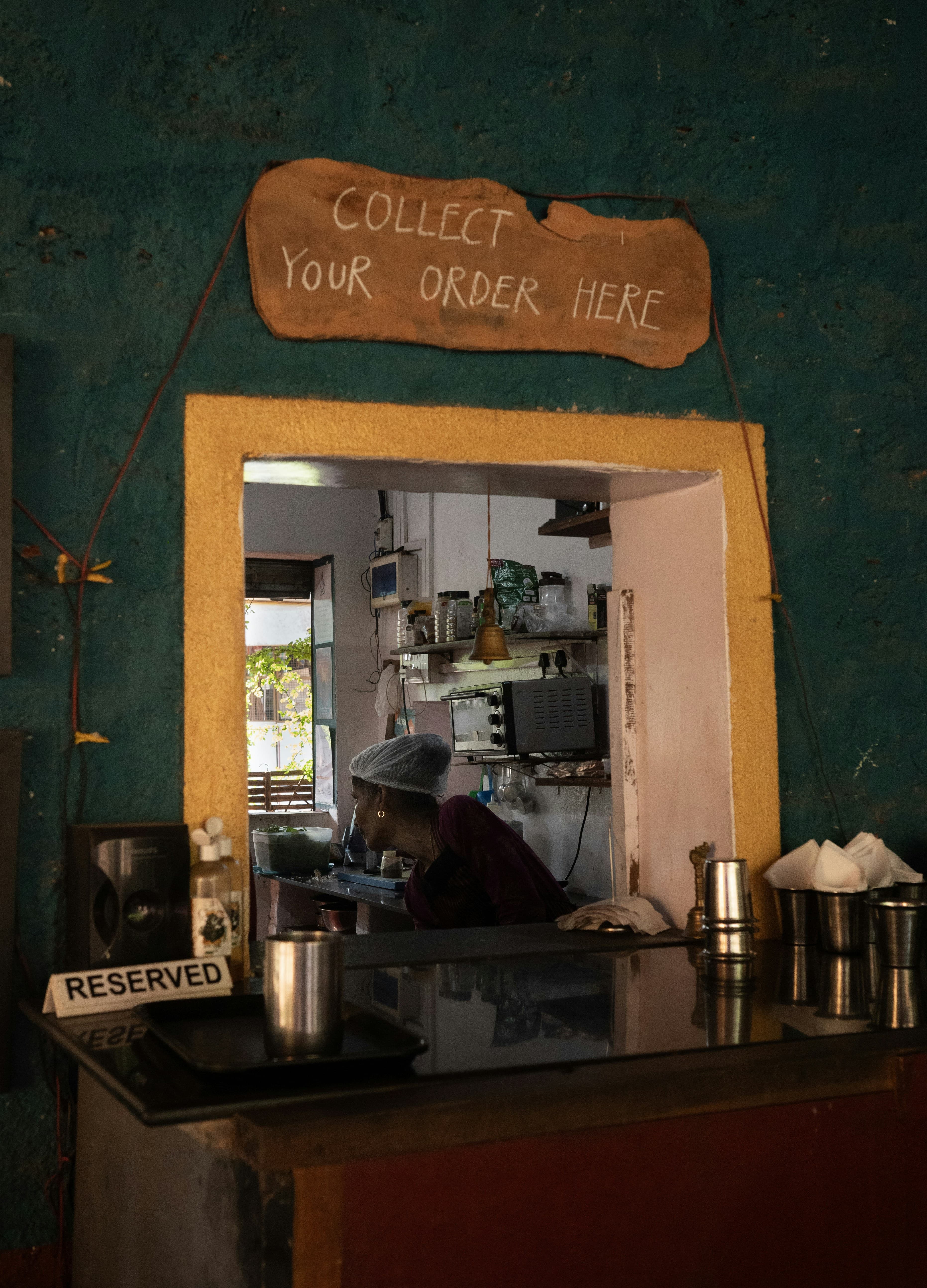 A restaurant pass window during service, with a cook working behind the counter